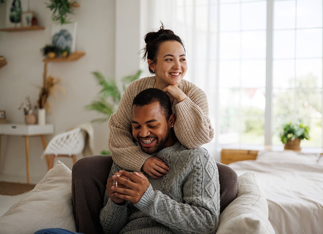 We Are Independent - Portrait of a Diverse Young Married Couple Having Fun Spending Time Together Sitting on the Sofa in the Living Room